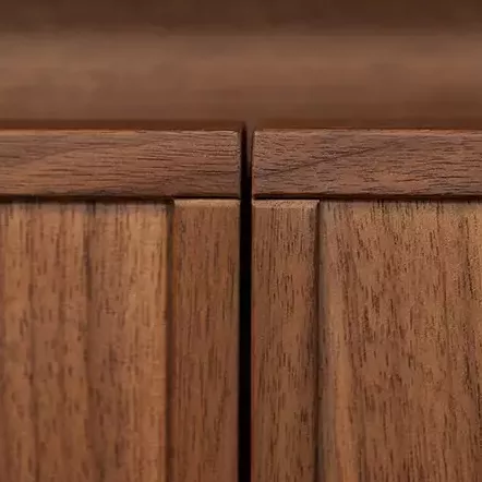 Gros plan sur les façades en noyer d'une cuisine design. Détails des finitions et de la texture du bois.