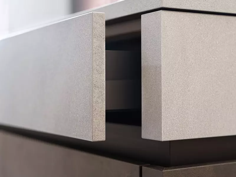 Zoom sur tiroir de cuisine finition béton clair avec ouverture sans poignée – Cuisine moderne et minimaliste sur cuisines-premier-plan.fr