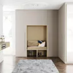 Espace d’entrée fonctionnel avec vestiaire intégré, assise rembourrée encastrée, rangements pour chaussures, armoires sur mesure et tapis moelleux sur un parquet en chevrons, baigné de lumière naturelle.