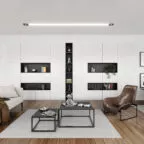 Salon moderne avec un mur de placards blancs et niches noires, canapé clair, fauteuil design marron, tables basses noires et parquet bois, ambiance minimaliste et fonctionnelle