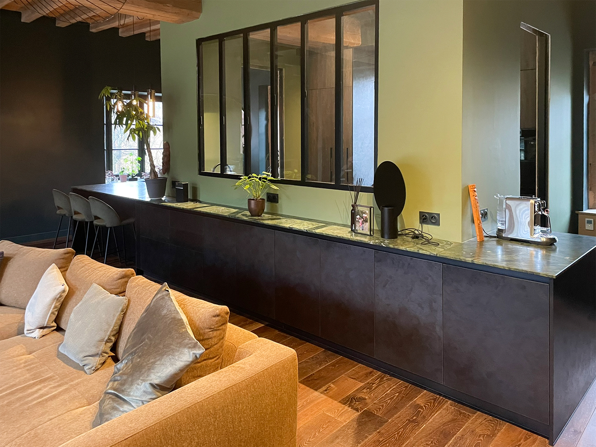 Découvrez un espace de vie chaleureux où la cuisine s’intègre parfaitement au salon grâce à des lignes épurées, des matériaux nobles et une palette de couleurs naturelles. Le plan de travail en pierre naturelle et les rangements sur-mesure signent le savoir-faire de Cuisines Premier Plan Le Bois d’Oingt
