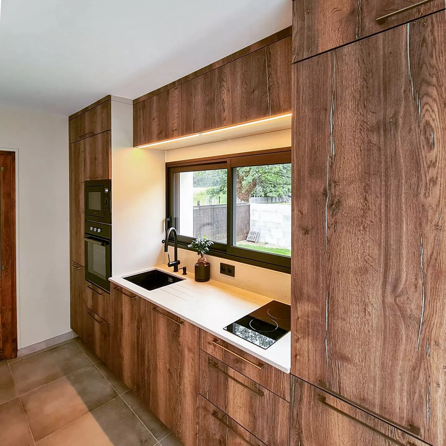 Profitez d’une perspective complète sur cette cuisine contemporaine, pensée pour optimiser chaque espace de rangement. L’association de l’électroménager intégré, du plan de cuisson moderne et des placards haut de gamme offre fonctionnalité et esthétique.