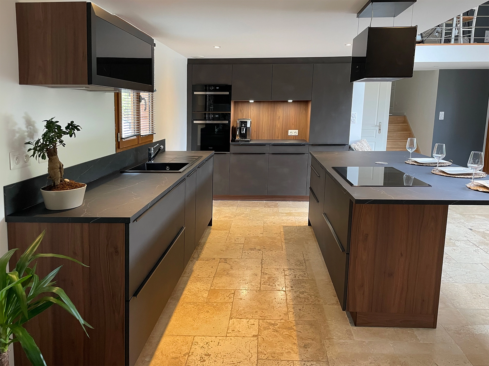Cuisine contemporaine conçue sur mesure sous la mezzanine, alliant élégance du bois, façades noir mat et plan de travail effet pierre. Ce projet Cuisines Premier Plan offre de multiples espaces fonctionnels, un îlot central convivial et une belle luminosité naturelle.