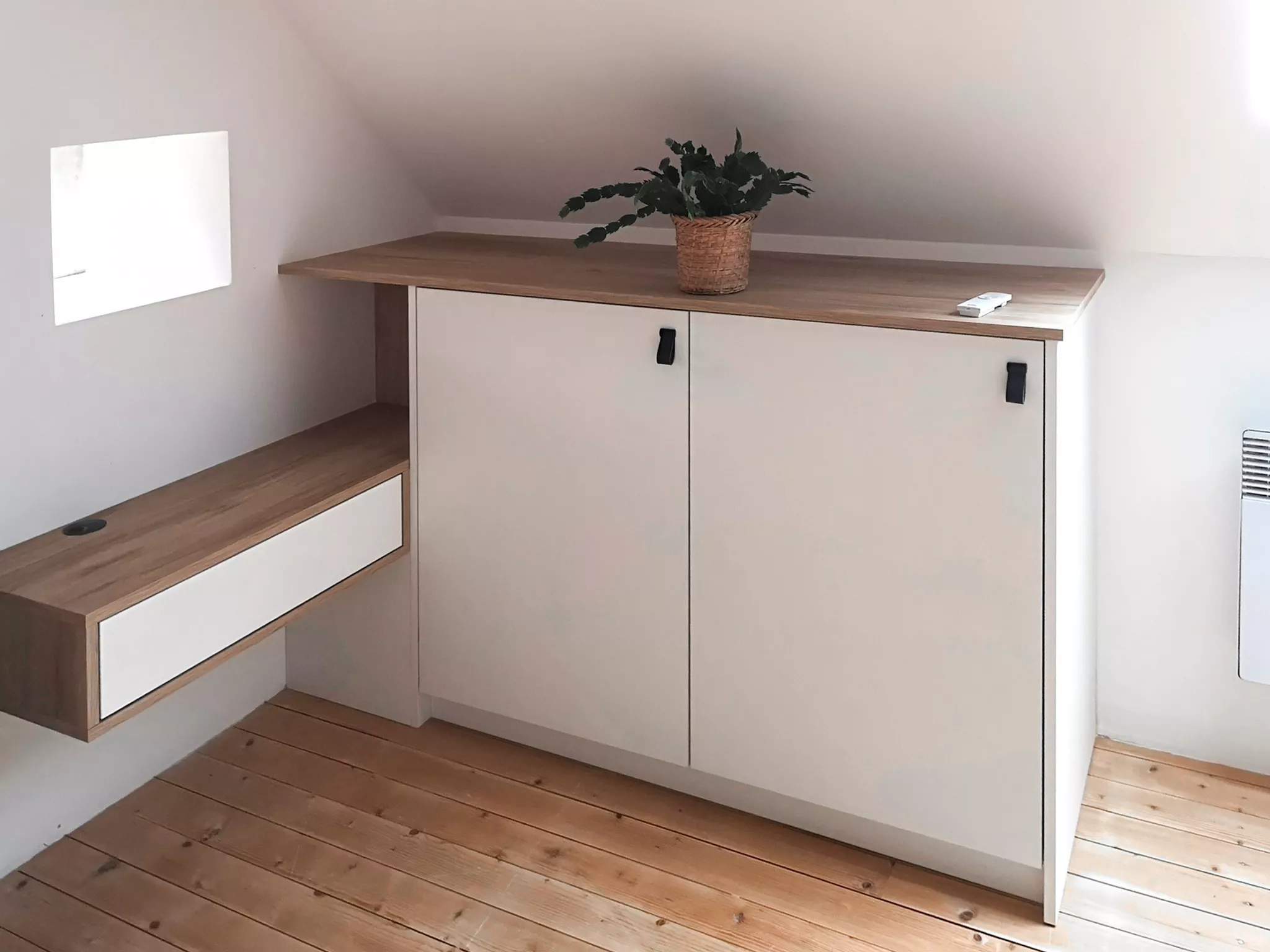 Meuble bas sur mesure en décor chêne clair et blanc mat, réalisé sous pente pour optimiser l’espace d’une mezzanine lumineuse signée Premier Plan Pont-l’Abbé.