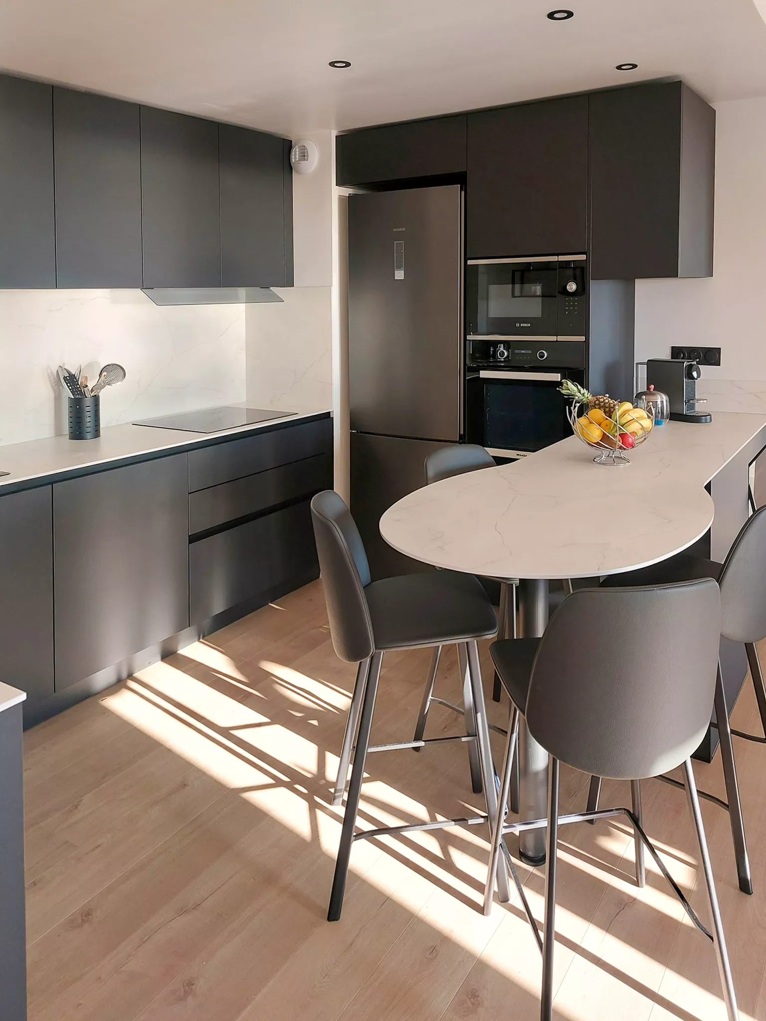 Ilot arrondi en compact blanc marbré intégré dans une cuisine sur mesure Le Havre — réalisation Premier Plan Le Havre.