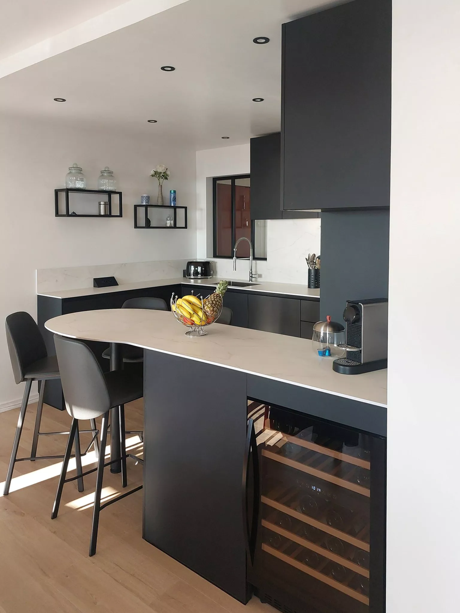 Plan de travail compact blanc marbré dans une cuisine sur mesure Le Havre, avec cuve sous-plan inox et robinetterie Luisina.