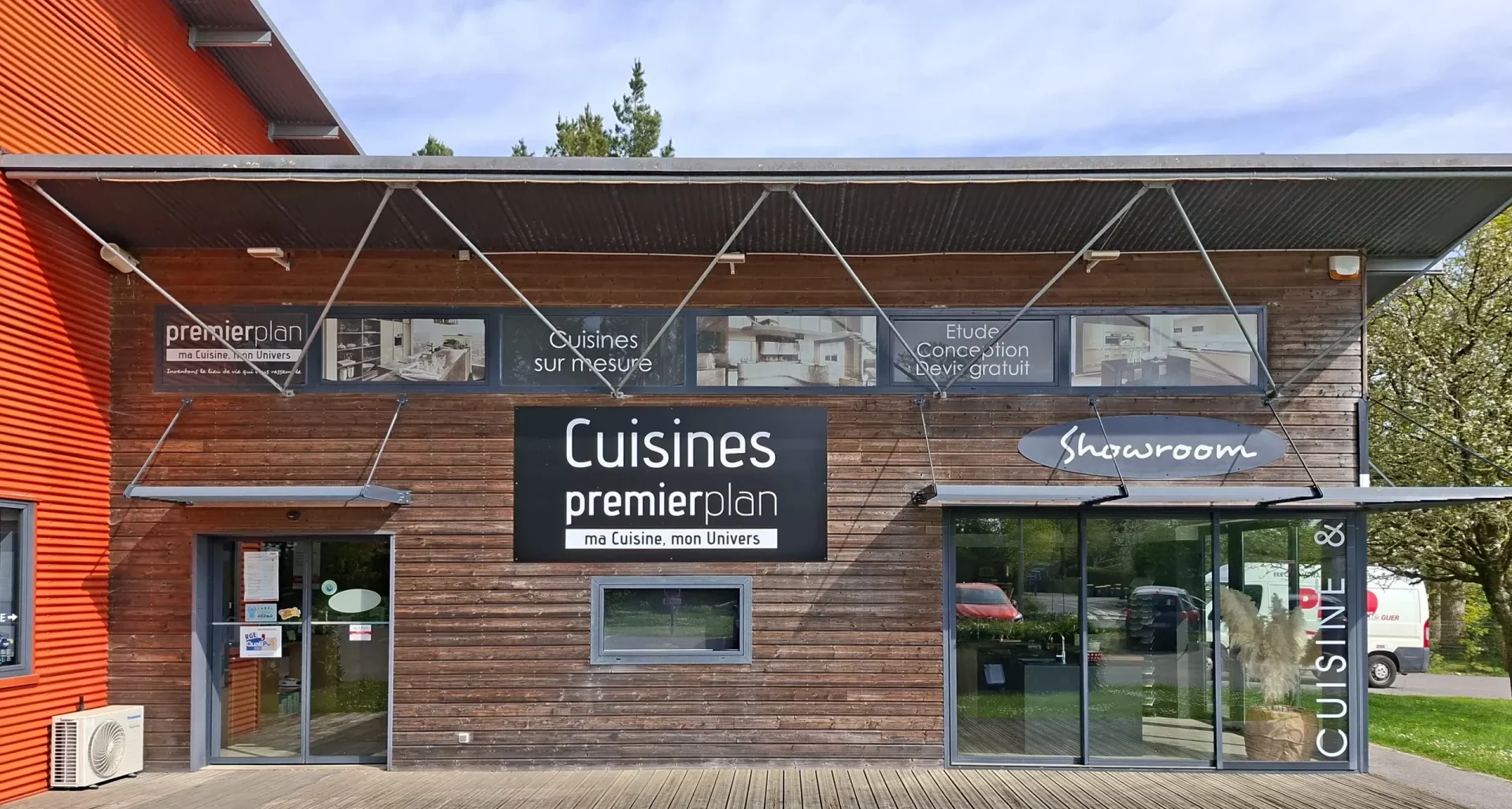 Façade extérieure du magasin Cuisines Premier Plan avec bardage bois, présentant le showroom, le service de conception sur mesure et l'étude gratuite de projets d'aménagement.