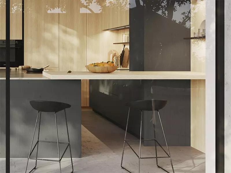 Coin repas sur l'îlot central d'une cuisine Rotpunkt avec tabourets de bar design.