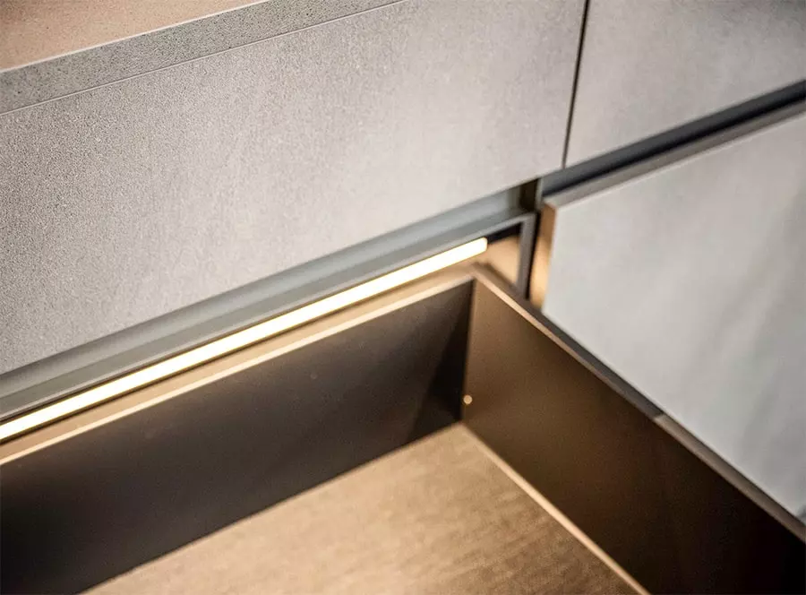 Détail d'un tiroir de cuisine Rotpunkt avec éclairage LED intégré et aménagement intérieur facilitant le rangement quotidien.