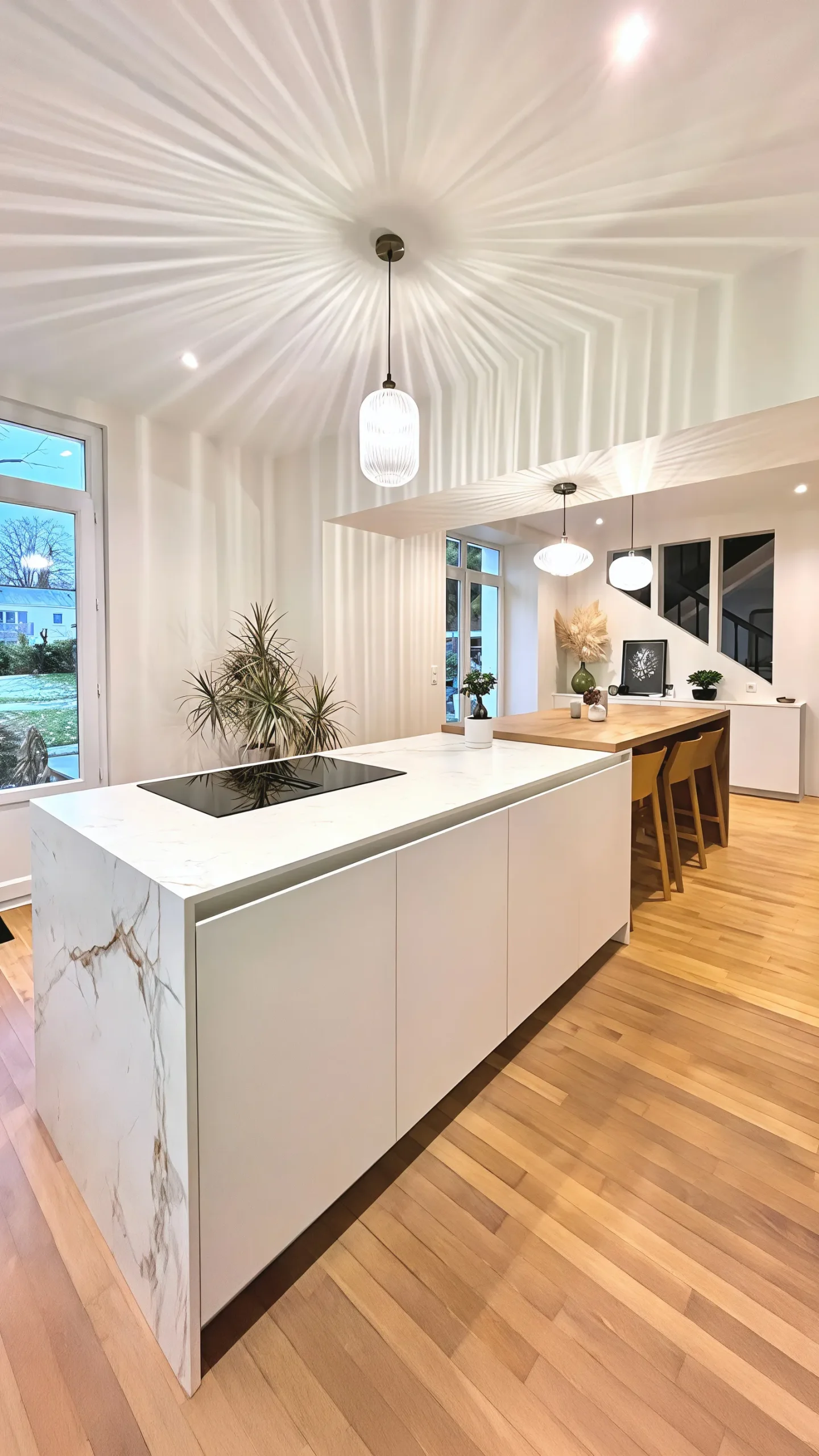 Cuisine sur mesure avec îlot central habillé d'un panneau effet marbre blanc veiné, plan de travail blanc, extension bar en bois massif, parquet chêne clair et spectaculaire plafond blanc en relief nervuré, réalisée par Cuisines Premier Plan à Nozay